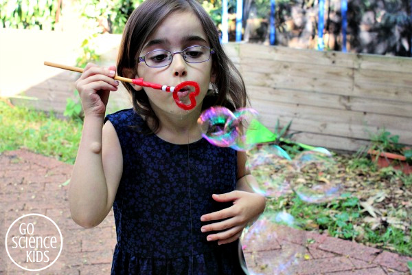 Blowing bubbles with a homemade heart bubble wand